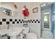 Unique bathroom featuring black and white tiled accents, quirky wall decor, and an enclosed shower with glass door at 4541 School Rd, Land O Lakes, FL 34638