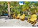 Private beach area with comfortable yellow Adirondack chairs under the shade of palm trees at 4541 School Rd, Land O Lakes, FL 34638