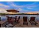 Relaxing waterfront dock area with comfortable seating, an umbrella table, and serene lake views perfect for entertaining at 4541 School Rd, Land O Lakes, FL 34638