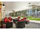 Relaxing screened lanai with comfortable seating, a fire pit, ceiling fans, and views of the lush backyard at 4541 School Rd, Land O Lakes, FL 34638