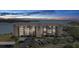 Exterior of a beachfront apartment building with multiple stories, parking, palm trees, and partial dusk lighting at 4550 Bay Blvd # 1231, Port Richey, FL 34668