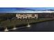 Exterior of a waterfront apartment building with multiple stories, parking, a fishing pier, palm trees, and dusk lighting at 4550 Bay Blvd # 1231, Port Richey, FL 34668