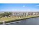 Exterior view of the waterfront apartment building and pier surrounded by trees, grass and blue skies at 4550 Bay Blvd # 1231, Port Richey, FL 34668