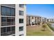 Exterior view of condominium building with balconies overlooking waterfront and grassy grounds at 4550 Bay Blvd # 1231, Port Richey, FL 34668