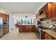 Spacious kitchen with wood cabinetry, granite countertops, a tile backsplash, and water views from the kitchen island at 4550 Bay Blvd # 1231, Port Richey, FL 34668