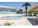 View of the pool with a palm tree, with the community center in the background at 4550 Bay Blvd # 1231, Port Richey, FL 34668