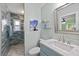 Bathroom featuring light blue cabinets, granite counters, and tiled shower at 4918 Forecastle Dr, New Port Richey, FL 34652