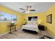 Bright bedroom with yellow walls, ceiling fan, and two windows offering pleasing outdoor views at 4918 Forecastle Dr, New Port Richey, FL 34652