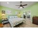 Bright bedroom with a ceiling fan, neutral decor, and a door to the office at 4918 Forecastle Dr, New Port Richey, FL 34652