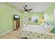 Bright bedroom with coastal-themed decor, ceiling fan, and wood-look floors at 4918 Forecastle Dr, New Port Richey, FL 34652
