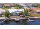 Waterfront home featuring a private boat dock with boat lift, patio, and red front door at 4918 Forecastle Dr, New Port Richey, FL 34652