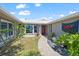 Charming home featuring a walkway to a bright red door and lush landscaping at 4918 Forecastle Dr, New Port Richey, FL 34652
