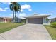 Single-story home with a two-car garage, white tiled roof, and well-kept lawn on a sunny day at 4918 Forecastle Dr, New Port Richey, FL 34652