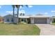 Charming single-story home featuring a two-car garage, red front door, and well-maintained lawn at 4918 Forecastle Dr, New Port Richey, FL 34652