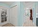 Inviting hallway with light blue walls, wood-look floors, and a view of a vintage grandfather clock at 4918 Forecastle Dr, New Port Richey, FL 34652