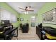 Bright home office with light green walls, wood-look floors, ceiling fan, and dark office furniture at 4918 Forecastle Dr, New Port Richey, FL 34652