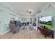 Open living room with bright light blue walls, ceiling fan, and views of the patio at 4918 Forecastle Dr, New Port Richey, FL 34652