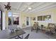 Enclosed patio features bright yellow walls, tropical print chairs and a ceiling fan at 4918 Forecastle Dr, New Port Richey, FL 34652