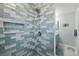 Sleek shower featuring blue-gray subway tile, a built-in niche, and modern fixtures at 4918 Forecastle Dr, New Port Richey, FL 34652