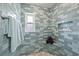 Modern shower with blue-gray tiling, a built-in niche, and a window for natural light at 4918 Forecastle Dr, New Port Richey, FL 34652