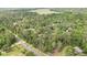 Overhead shot of a wooded area with glimpses of a house on a spacious lot and road in the distance at 5113 Cedar Ln, Brooksville, FL 34601