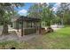 Grassy backyard featuring a covered patio with bar, built in benches, and an above ground pool at 5113 Cedar Ln, Brooksville, FL 34601