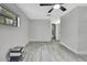 Spacious bedroom boasts gray wood floors and a ceiling fan at 5113 Cedar Ln, Brooksville, FL 34601
