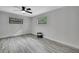 Bedroom features gray wood floors and natural light from two windows at 5113 Cedar Ln, Brooksville, FL 34601