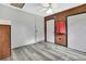 Bedroom features gray wood floors, a ceiling fan, and two white doors at 5113 Cedar Ln, Brooksville, FL 34601