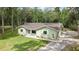 Charming single story home with a light green exterior and spacious front yard surrounded by mature trees at 5113 Cedar Ln, Brooksville, FL 34601