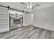 Living room with a modern sliding barn door that opens into the kitchen, and sleek gray wood-look floors at 5113 Cedar Ln, Brooksville, FL 34601