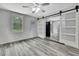 Living room featuring neutral walls, sliding barn door, and gray wood-look flooring and natural light at 5113 Cedar Ln, Brooksville, FL 34601