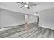 Expansive living room with neutral color walls, fan and gray wood-look floors at 5113 Cedar Ln, Brooksville, FL 34601