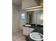 Bathroom featuring dual sinks with green countertops and a large mirror at 5294 Elkin Ave, Spring Hill, FL 34606