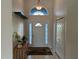 Bright entryway featuring tile flooring, a decorative shelf, and a glass window above the front door at 5294 Elkin Ave, Spring Hill, FL 34606