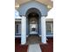 Inviting front entryway with white columns and an arch that frames the decorative glass front door at 5294 Elkin Ave, Spring Hill, FL 34606