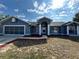 Single story home with a two-car garage and a decorative columned entrance. and landscaped front yard at 5294 Elkin Ave, Spring Hill, FL 34606