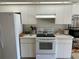 Well-lit kitchen featuring white cabinets, range, and appliances, offering ample storage at 5294 Elkin Ave, Spring Hill, FL 34606