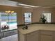 Tile-floored kitchen with white cabinets, offering views of the outdoor pool area and natural light at 5294 Elkin Ave, Spring Hill, FL 34606