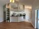 Open-concept living area featuring hardwood floors, bright kitchen with black countertops, and shelving at 5294 Elkin Ave, Spring Hill, FL 34606