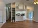 Open-concept living area featuring hardwood floors, bright kitchen, and shelving at 5294 Elkin Ave, Spring Hill, FL 34606