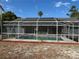 A screened-in swimming pool area with seating area, landscaping, and privacy at 5294 Elkin Ave, Spring Hill, FL 34606