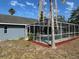 A screened-in swimming pool area with landscaping and nearby trees at 5294 Elkin Ave, Spring Hill, FL 34606