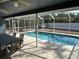 Sparkling screened-in pool with a covered patio, dining area, and backyard view at 5294 Elkin Ave, Spring Hill, FL 34606