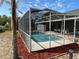 A screened-in swimming pool area with seating area, landscaping, and privacy at 5294 Elkin Ave, Spring Hill, FL 34606