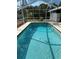 A screened-in swimming pool features clear blue water and accessibility rails for easy and safe enjoyment at 5294 Elkin Ave, Spring Hill, FL 34606