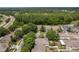 Wide aerial shot of a residential area featuring lush greenery, nearby lake, and roadways at 6125 Desert Peace Ave, Land O Lakes, FL 34639