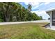 A view of the spacious backyard, surrounded by a white vinyl fence and mature trees at 6125 Desert Peace Ave, Land O Lakes, FL 34639