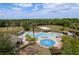 A large community pool area featuring a splash zone, palm trees, and plenty of lounge chairs at 6125 Desert Peace Ave, Land O Lakes, FL 34639