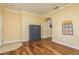 Bright, empty room with hardwood floors, tan walls, safe, and archway at 6125 Desert Peace Ave, Land O Lakes, FL 34639